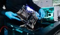 Closeup of technician installing motherboard inside computer case in modern lab, symbolizing innovation, hardware repair Royalty Free Stock Photo