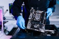 Closeup of technician installing motherboard inside computer case in modern lab, symbolizing innovation, hardware repair Royalty Free Stock Photo