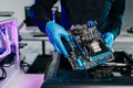 Closeup of technician installing motherboard inside computer case in modern lab, symbolizing innovation, hardware repair Royalty Free Stock Photo