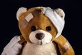 Closeup of teddy bear bandaged with bandages and band aid, concept of child abuse or violence, image representing domestic