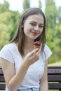 Closeup of teenage girl relaxing in the park, eating a ice creame, on a bench. Smiling young woman. Summer time, outdoor Royalty Free Stock Photo