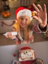 Closeup on teenage girl in santa hat showing candie in kitchen Royalty Free Stock Photo