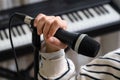 Closeup of teenager recording music in home studio. Girl with headphones and microphone recording song