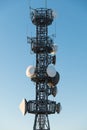 Closeup telecommunication tower with satellite dishes on blue sky background Royalty Free Stock Photo