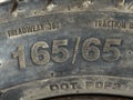 The text 165 65 showing width and aspect ratio of a tyre