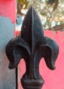 Closeup texture detail of decorative symbol of wrought iron gate with Fleur de lis pattern on vertical fence