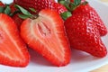 Closeup the Texture of Fresh Ripe Strawberry Cross Sections with the Whole Fruits on White Plate Royalty Free Stock Photo
