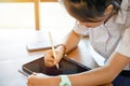 Closeup Thai girl student using and study on tablet at school with sun flare background. Royalty Free Stock Photo