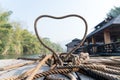 Closeup thick rope tie the heart shape on the wooden terrace near river