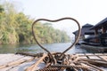 Closeup thick rope tie the heart shape on the wooden terrace near river