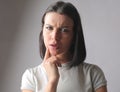 Closeup of a thoughtful Hungarian brunette looking at the camera with a confused, curious expression