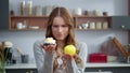 Closeup thoughtful woman looking at creamy dessert and fresh apple in kitchen Royalty Free Stock Photo