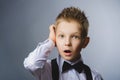 Closeup Thoughtful Young Boy Looking Up with Hand on Face Against Gray Background Royalty Free Stock Photo