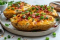 Closeup three baked potatoes topped with bacon, green onions and cheddar cheese on white plate Royalty Free Stock Photo