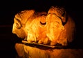 Closeup of three bison statues gleaming in the dark