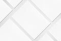 Closeup of three empty white rectangle poster mockups lying diagonally on grey textured background