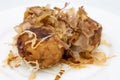 Closeup of Three Japanese Takoyaki  Balls with Bonito Flakes on a White Plate Royalty Free Stock Photo