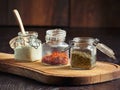 A closeup of three jars of spices and white sauce