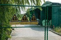 Closeup of three signs of Hazardous Waste Area on a factory gate in CHINA