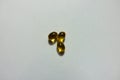 Closeup of three yellow softgel capsules of vitamin A retinyl palmitate