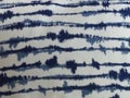 Closeup of tie-dye style blue stripes on white linen