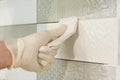 Closeup of tiler hand rubbing tile, Installing and grouting decorative finishes in environments with an high aesthetic value. Two-