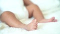 Closeup tiny newborn baby toes feet on coverlet blanket