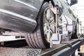 Closeup of tire clamped with aligner undergoing auto wheel align