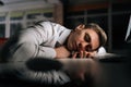 Closeup of tired sleepy male employee asleep on computer desk late at night. Exhausted businessman sleeping with head on Royalty Free Stock Photo