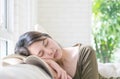 Closeup tired woman sleep after she read a book at the sofa in living room textured background