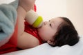 Closeup to Asian Thai Sweet Baby Girl Sucking Milk from Bottle Royalty Free Stock Photo
