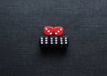 Closeup to a black and red dices. three black dices and two red dices over black background. Royalty Free Stock Photo