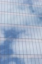 Closeup to a blue cloudy sky reflecting on a modern skyscraper window Royalty Free Stock Photo