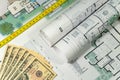 Closeup to floor plans, measuring yellow tape and US dollars. Architect drawings, expensive renovation, building construction