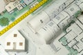 Closeup to floor plans, white paper house, measuring yellow tape. Architect drawings, expensive renovation,  building construction Royalty Free Stock Photo