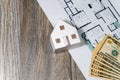 Closeup to floor plans, white paper house, measuring yellow tape and US dollars. Architect drawings, expensive renovation Royalty Free Stock Photo