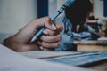 Closeup to hand of student holding pen and taking exam in classroom with stress for education test. Royalty Free Stock Photo