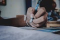 Closeup to hand of student holding pen and taking exam in classroom with stress for education test. Royalty Free Stock Photo