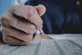 Closeup to hand of student holding pen and taking exam in classroom with stress for education test. Royalty Free Stock Photo