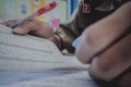 Closeup to hand of student holding pen and taking exam in classroom with stress for education test. Royalty Free Stock Photo