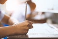 Closeup to hand of student  holding pencil and taking exam in classroom with stress for education test Royalty Free Stock Photo