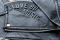 Closeup to a love 80 music lettering art over a black leather biker jacket with LP vinyl disc