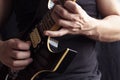 Closeup to a man wearing a black t-shirt playing a black and yellow electric guitar with wooden background Royalty Free Stock Photo