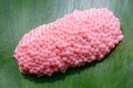 Closeup to shellfish cherry egg on white green leaf.