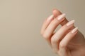 Closeup to woman hands with elegant neutral colors manicure. Beautiful nude manicure on long almond shaped nails. Nude