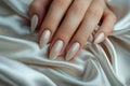 Closeup to woman hands with elegant neutral colors manicure on long almond shaped nails. Female hands with luxury nude