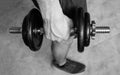 Closeup to a young man holding and squeezing an iron dumbbell Royalty Free Stock Photo