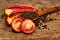 Closeup Tomaten, Red hot chili peppers and black pepper whole in wooden spoon on old wooden background Royalty Free Stock Photo