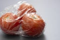 Closeup tomatoes in wrapping plastic stretch film, abstract plastic waste concept