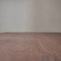 Closeup toned black walnut surface with white wall on background Royalty Free Stock Photo